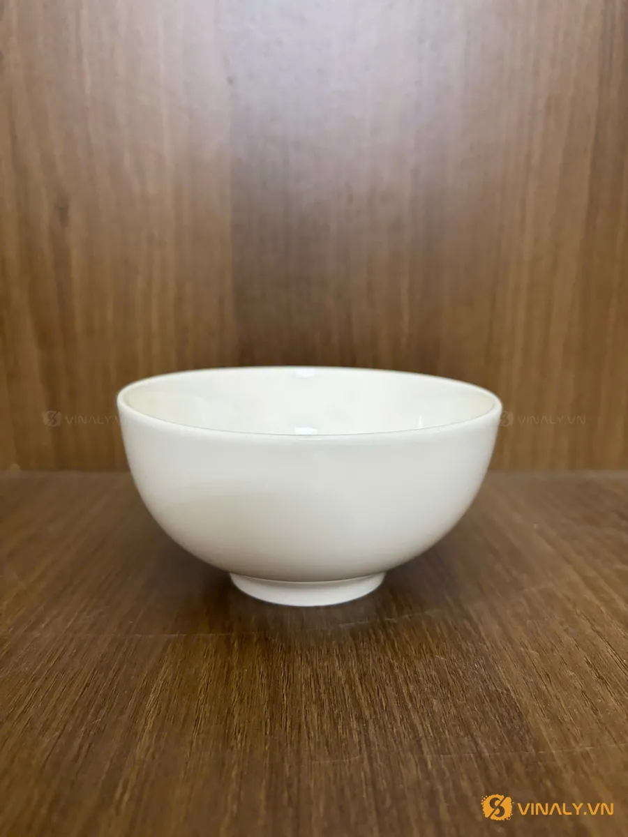 Hình ảnh chén sứ trắng trơn, kiểu dáng đơn giản, đặt trên mặt bàn gỗ nâu, phù hợp làm quà tặng doanh nghiệp với dịch vụ in