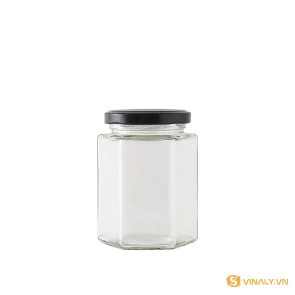 Hũ lục giác 280ml 4 Hình ảnh hũ lục giác 280ml in logo, chất liệu thủy tinh trong suốt với nắp vặn màu đen, đặt trên nền trắng tinh khiết.