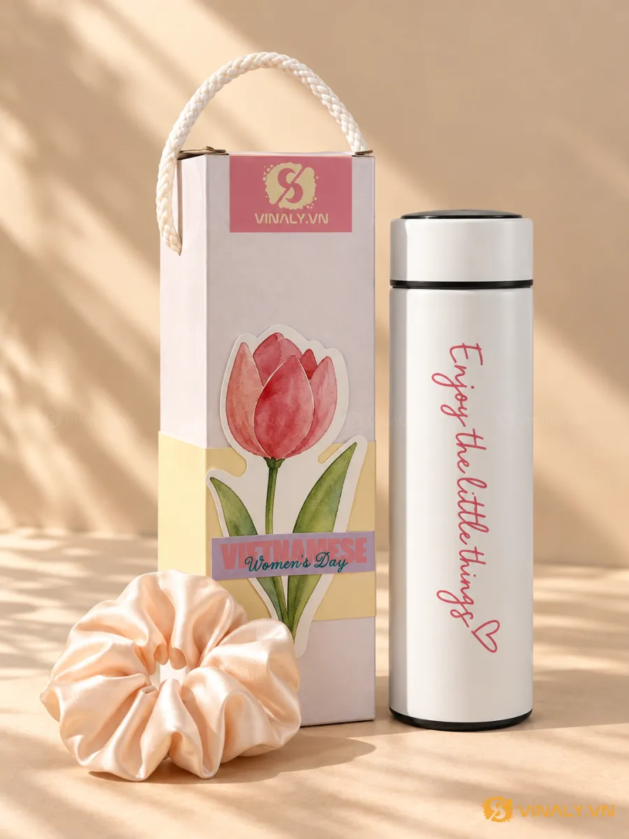 Bình giữ nhiệt trắng in logo với chữ hồng 'Enjoy the little things', hộp quà trang trí hoa tulip và scrunchie hồng nhạt, quà