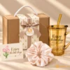 Set Quà 20/10 Tone Nâu Thanh Lịch – Món Quà Ấm ÁP, Thiết Thực Cho Doanh Nghiệp 1 Ly nhựa có quai ống hút in logo màu hổ phách, có ống hút, in chữ "Enjoy the little things", kèm scrunchie hồng và hộp quà